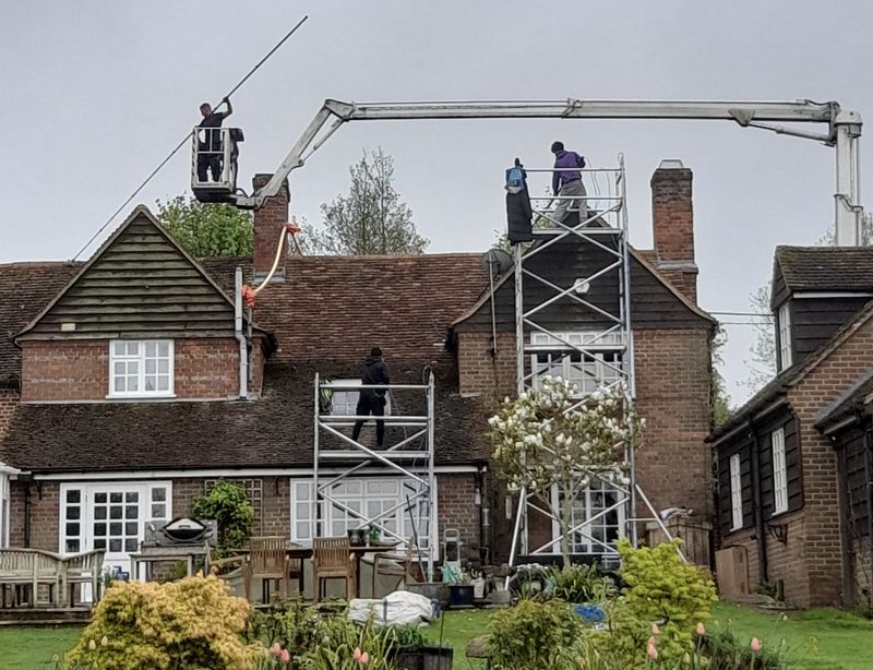 The Moss Cleaners using cherry picker and scaffolding to clean roof safely and professionally in East Horsley, Surrey